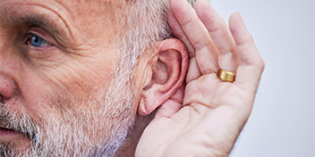 man-holding-ear-hearing-loss