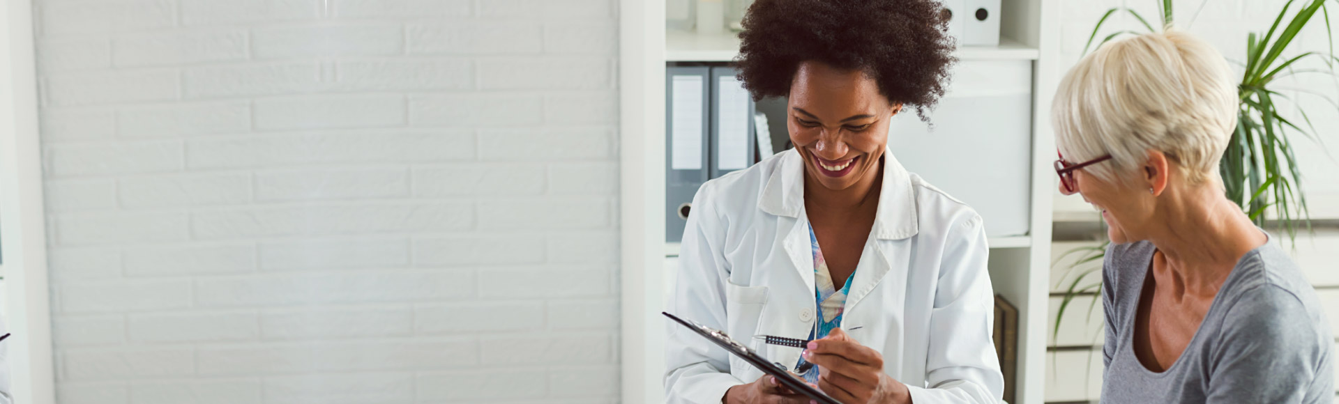 Image shows woman and audiologist looking at ipad