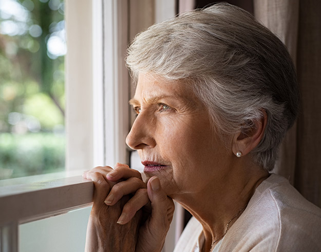 Image shows woman looking out of the window